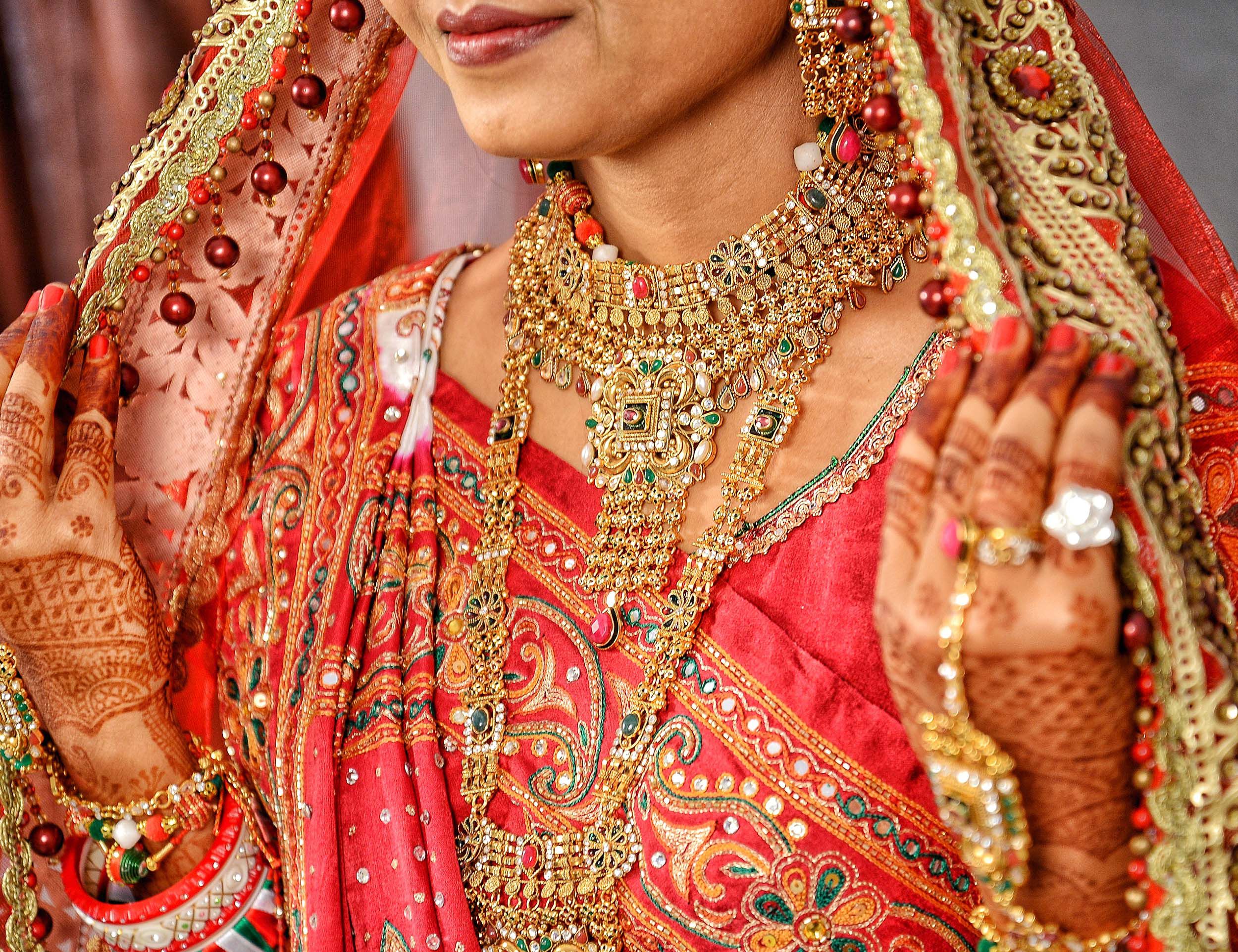 A bride flaunting her beautiful traditional gold necklace with stylish embraided jewellery